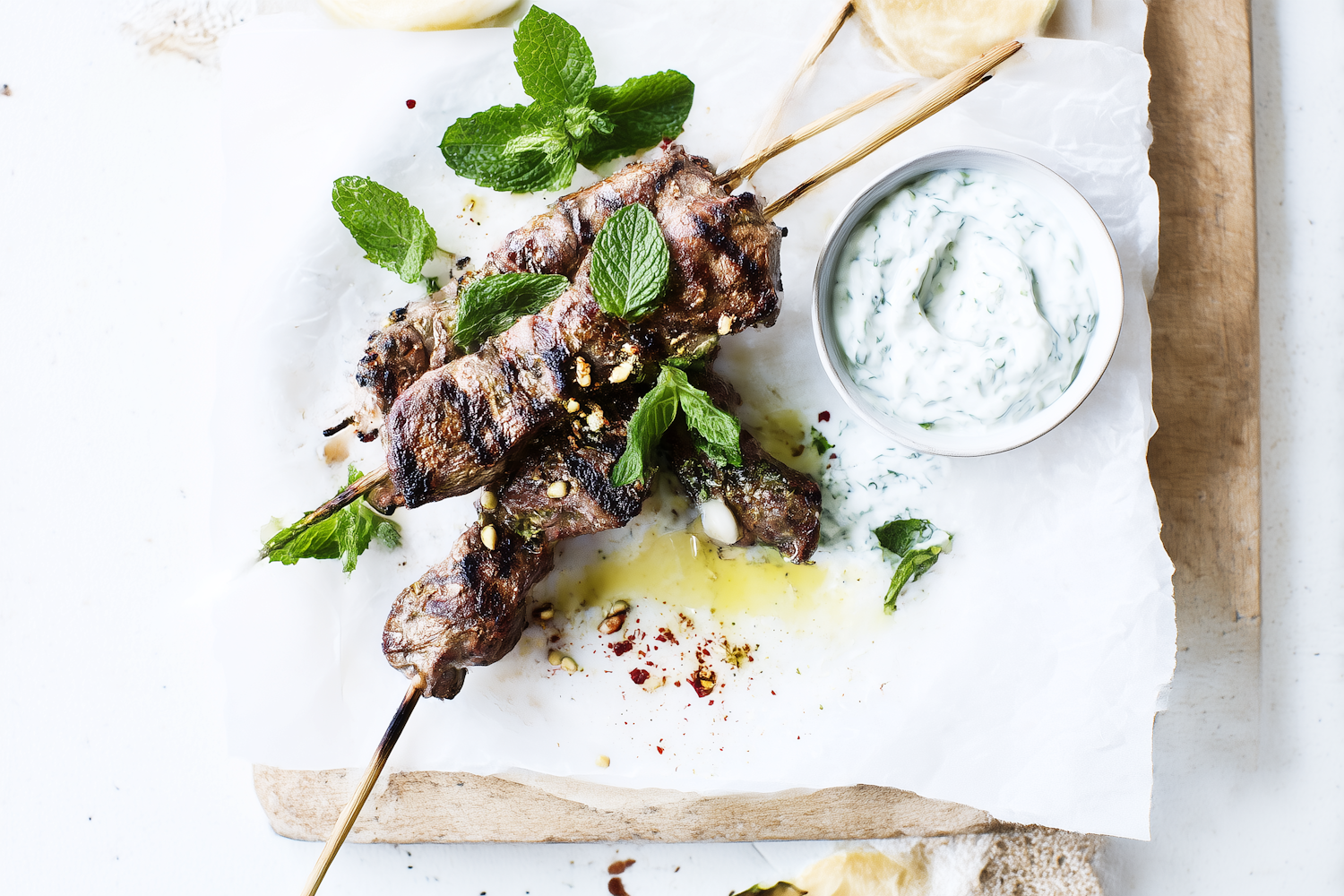 A platter of grilled meat served with flatbread and sauces